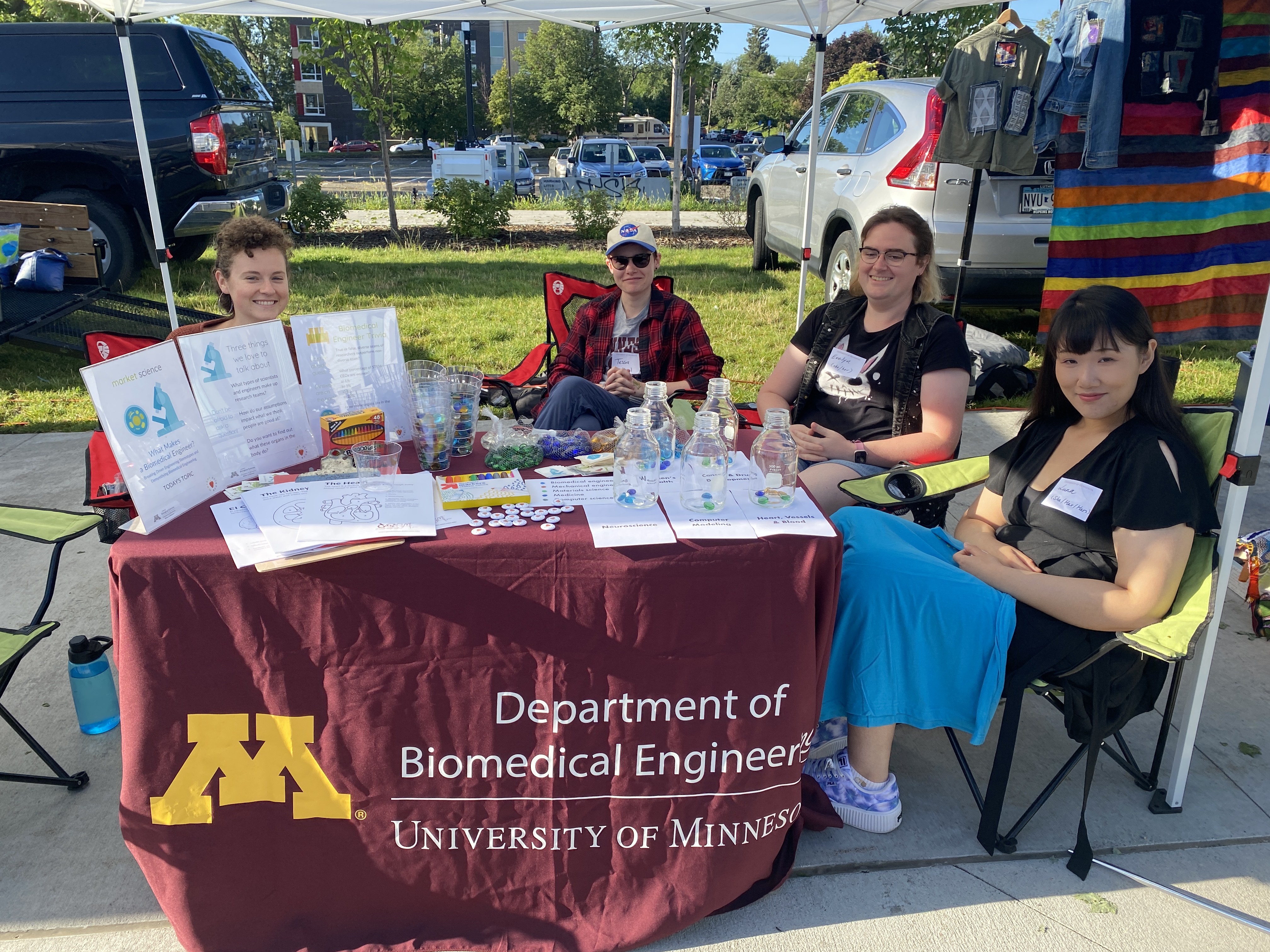 A group of women at a farmer's market booth about biomedical engineering